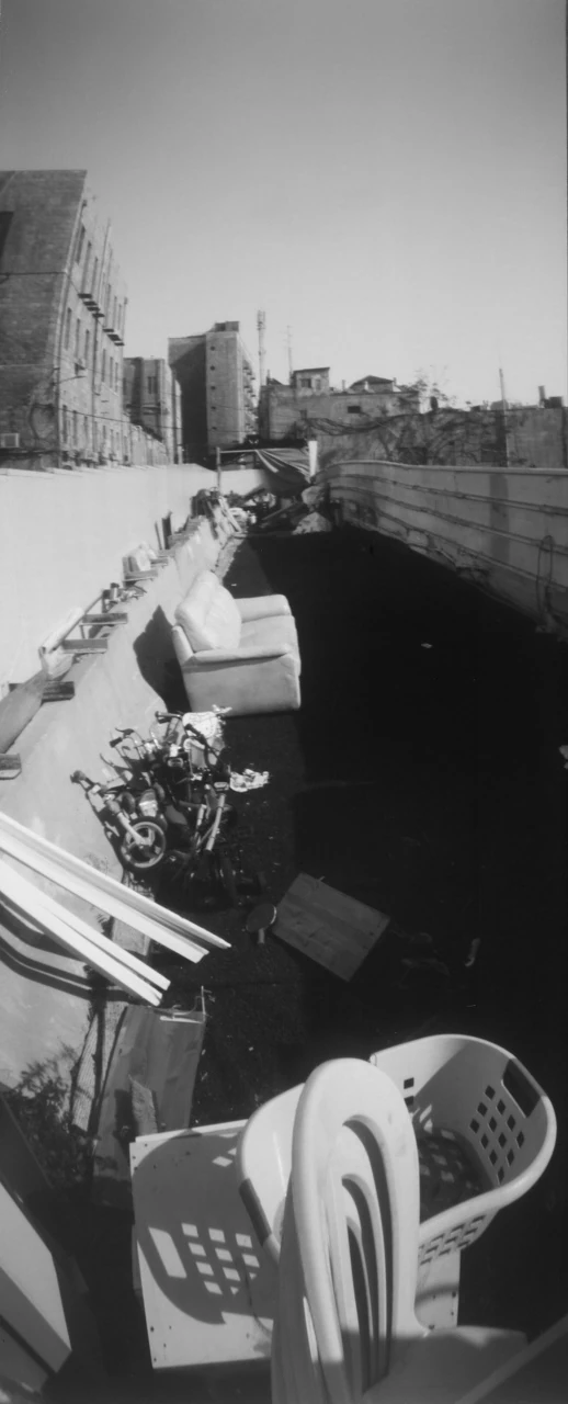 A narrow black-and-white view of balconies and city rooftops