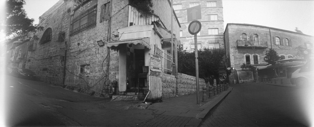 A rounded black-and-white view of a street corner and buildings