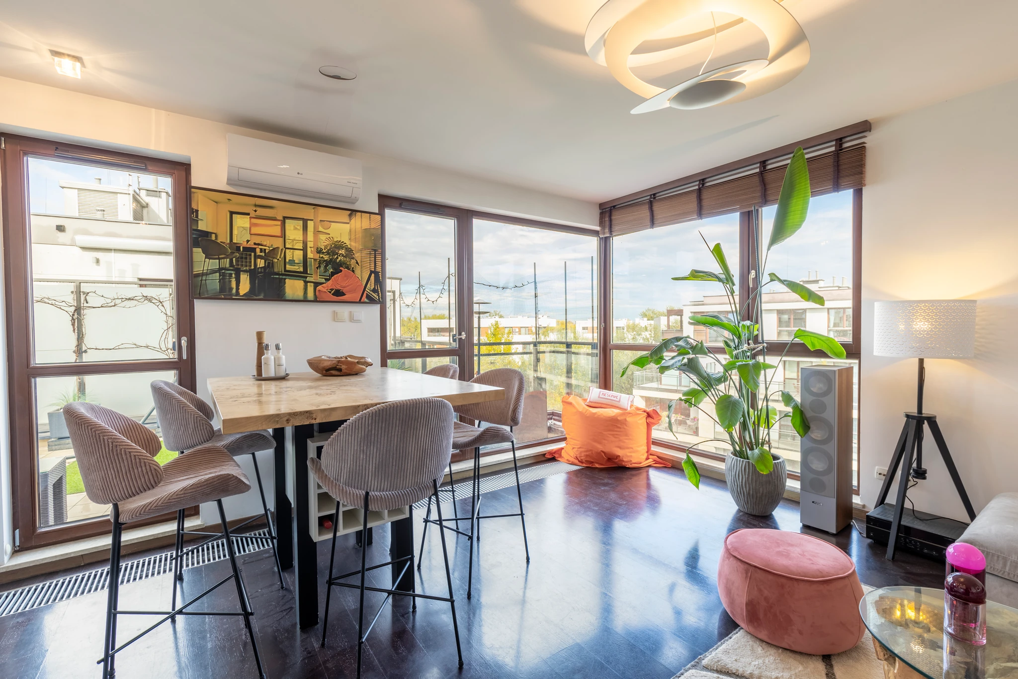 Sunlit open-plan living and dining room with balcony windows