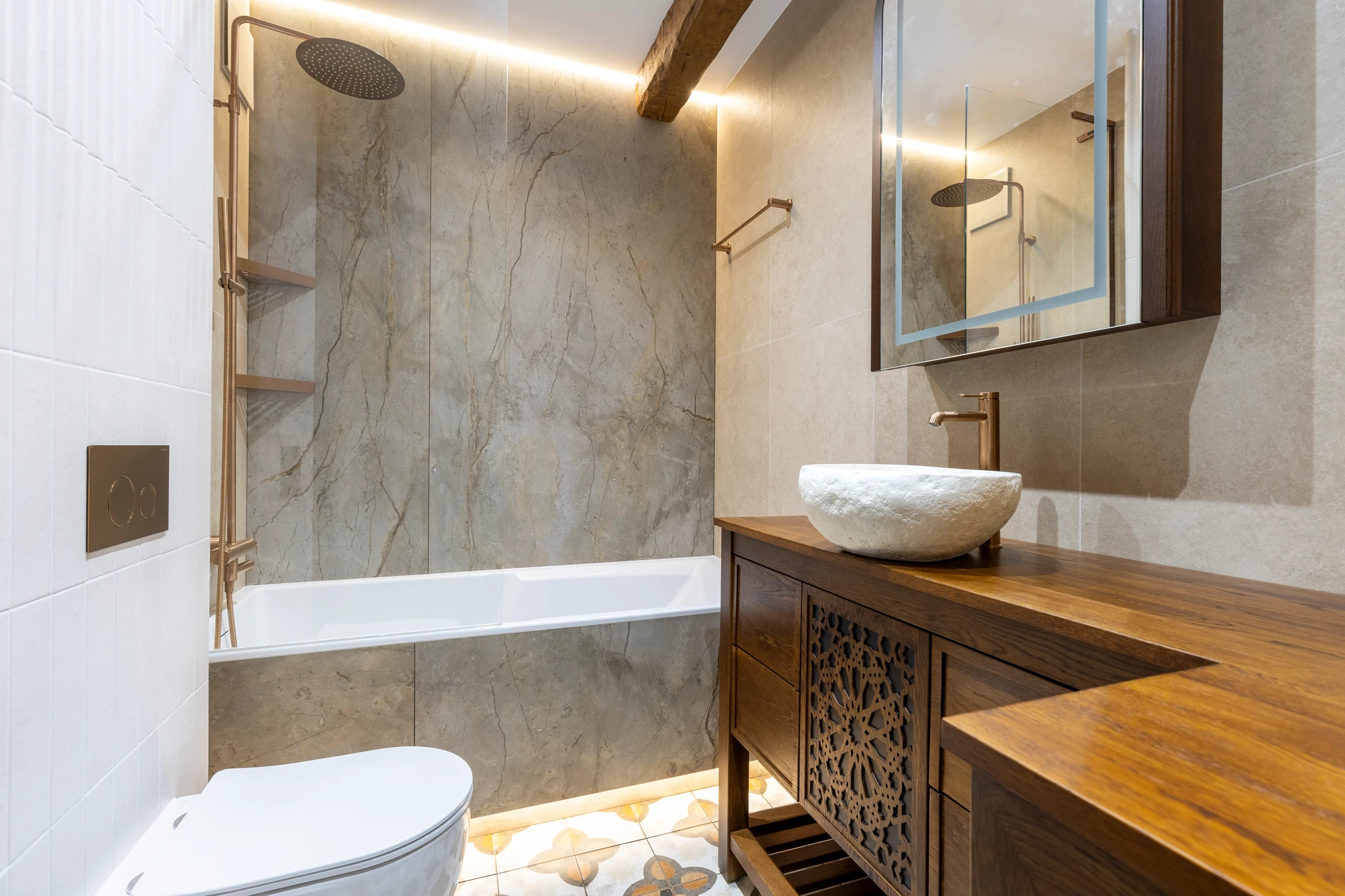 Bathroom with a bathtub, stone vessel sink and wooden vanity