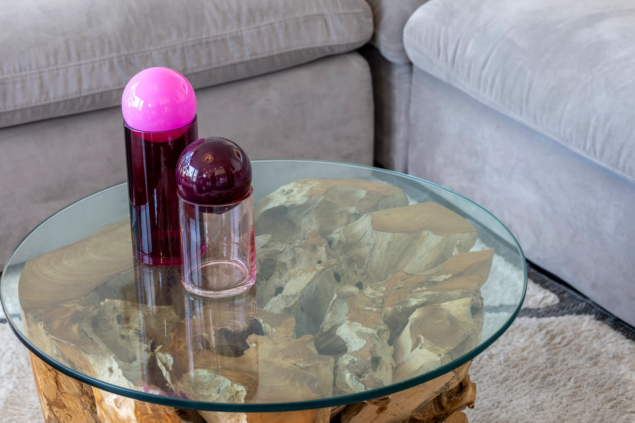 Purple glass ornaments on a round glass coffee table