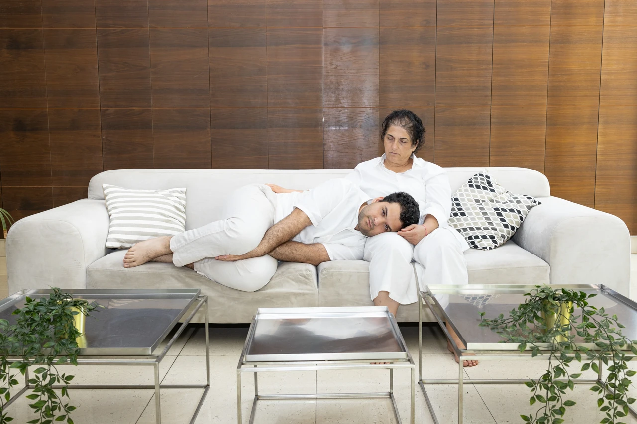 Two people dressed in white resting on a sofa