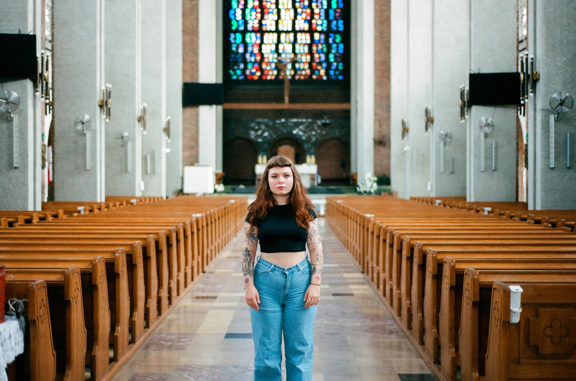 A person standing between rows of church pews