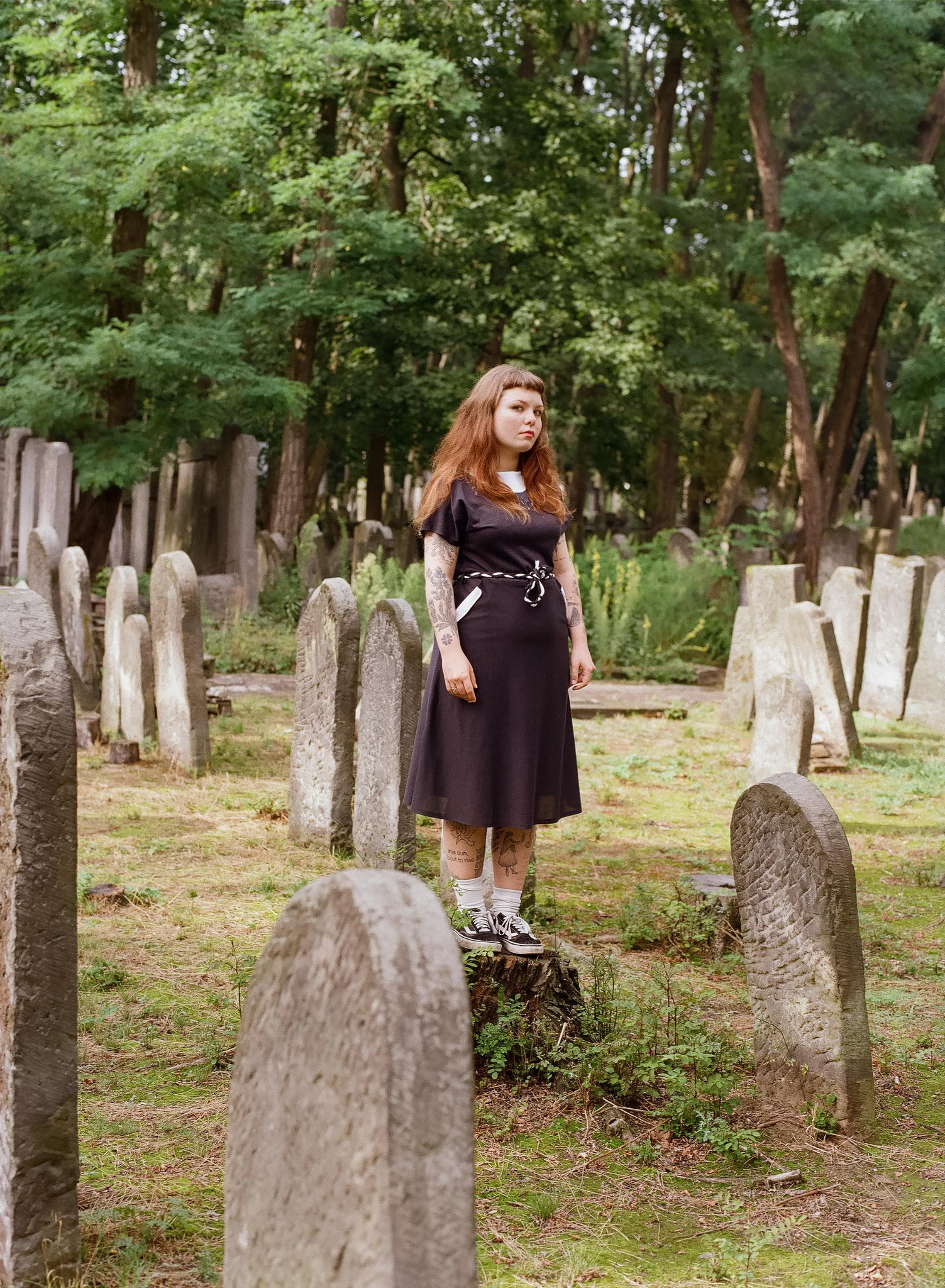A person standing among headstones in a cemetery